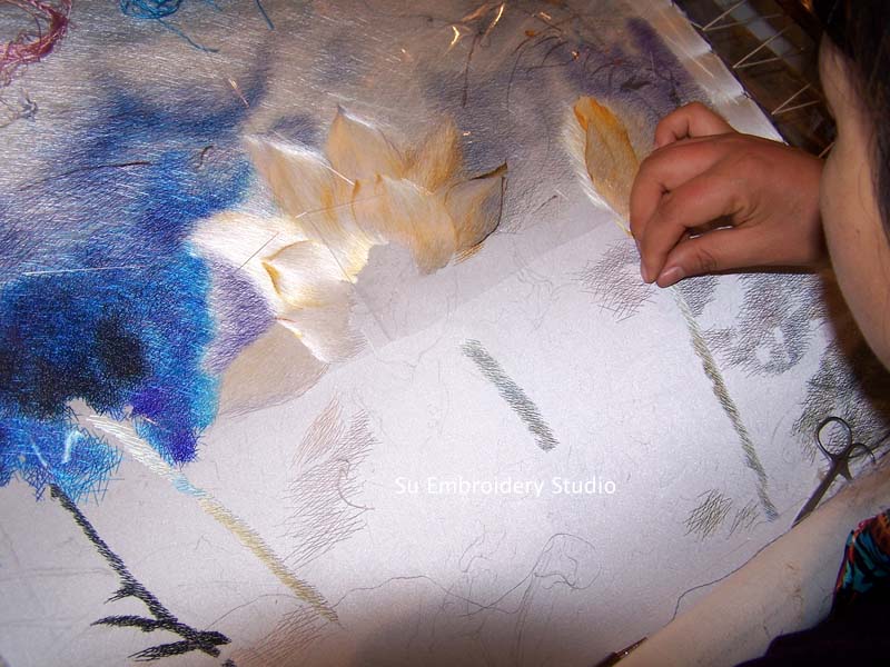 a Chinese embroidery artist embroidering a lotus flower silk embroidery